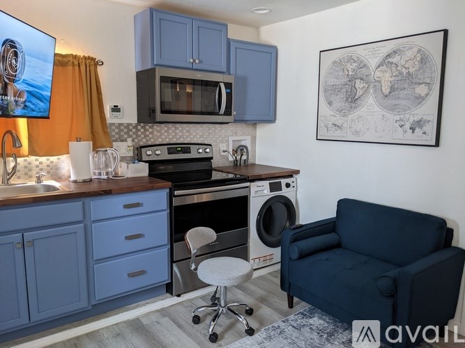 A kitchen with blue cabinets and a washing machine.