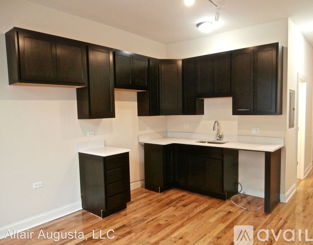 A kitchen with black cabinets and a white countertop is available.