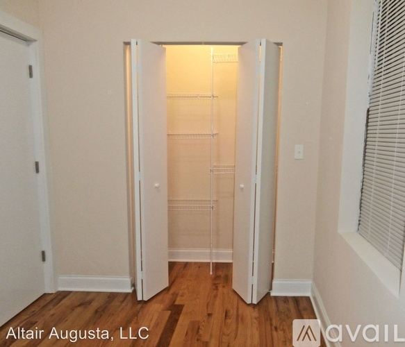 A room with a white door and a wooden floor.
