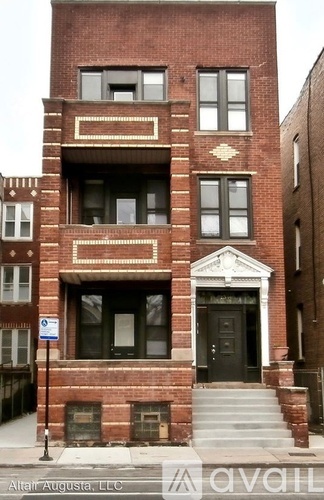A red brick building with a black door and windows.
