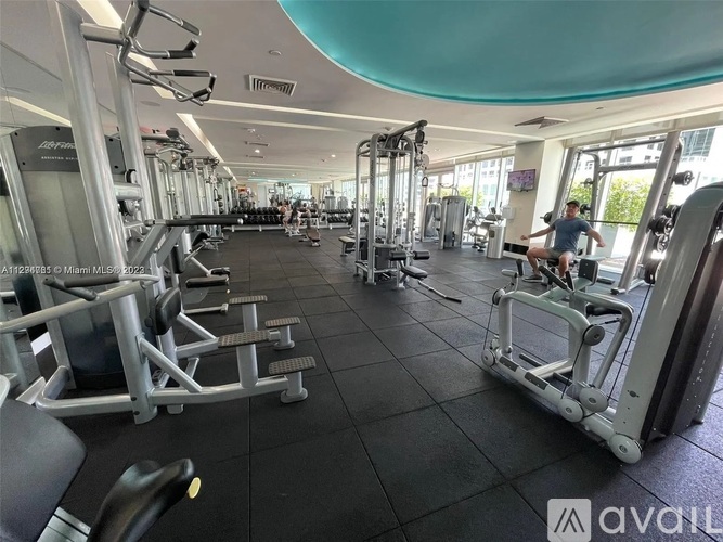 A gym with a variety of equipment including treadmills, weights, and exercise machines.