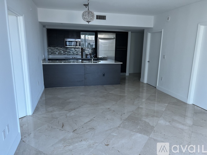 A kitchen with a marble floor and a hanging light fixture.