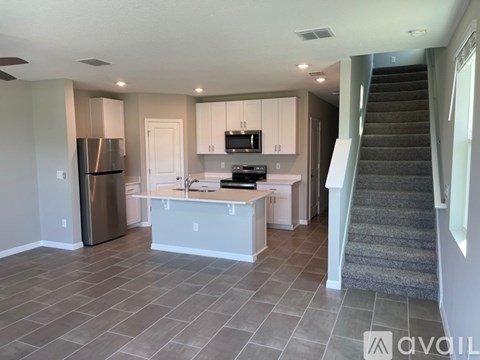 A kitchen with a refrigerator, microwave, and stove top oven.