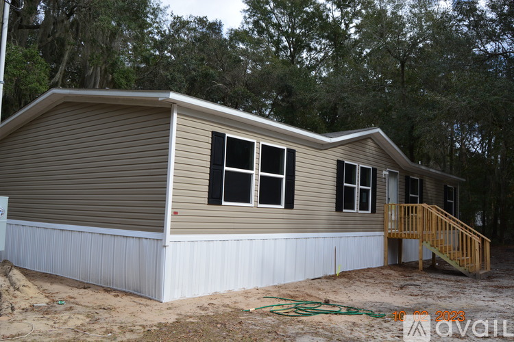 A house under construction with a brown and beige exterior and a white base.