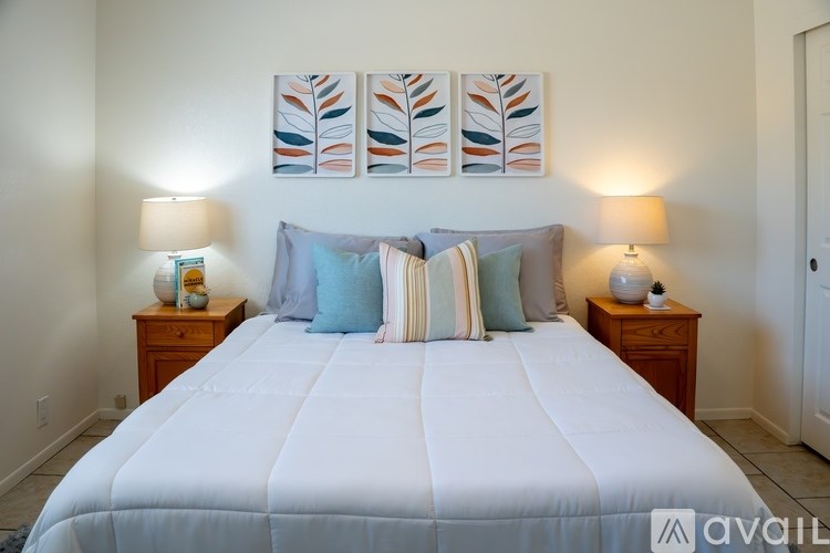 A bedroom with a large bed and two lamps on side tables.