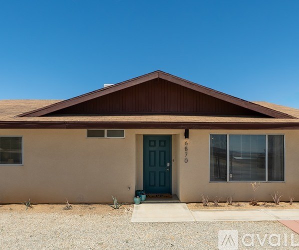 A house with a blue door and a brown roof.