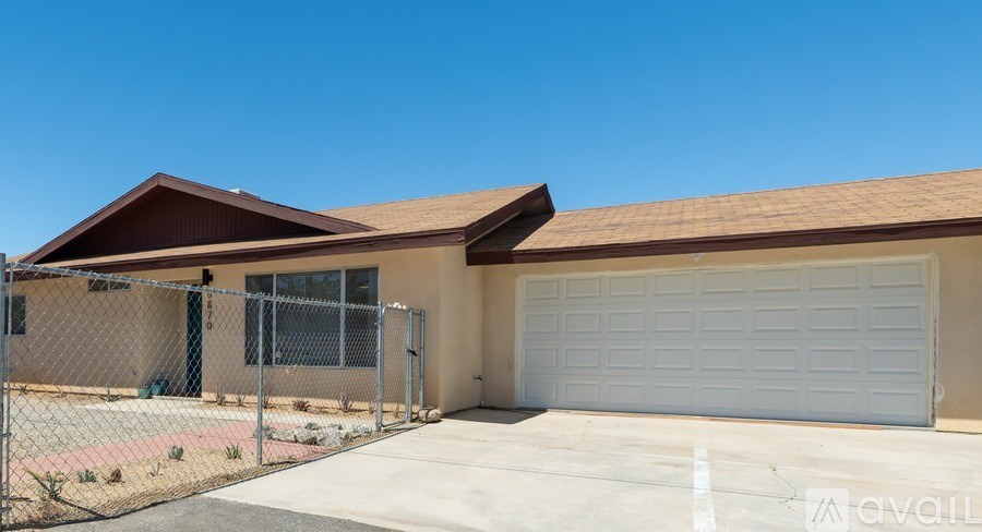 A house with a white garage door and a brown roof.