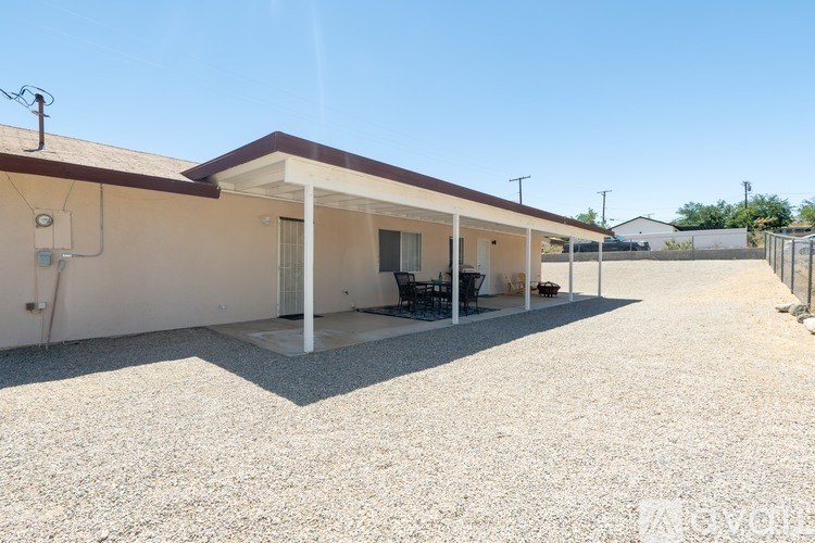 A house with a gravel driveway and a covered patio area.