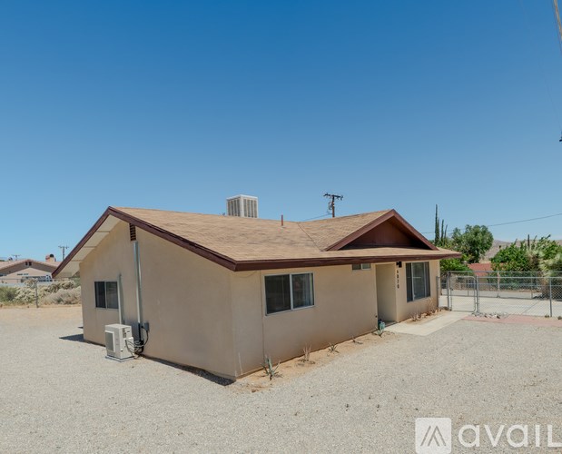 A house with a brown roof and beige walls is for sale.
