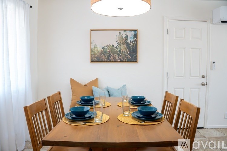 A dining room with a wooden table set for two.