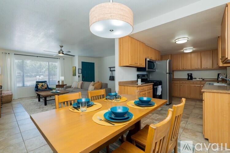 A kitchen with a table set for four with blue plates.