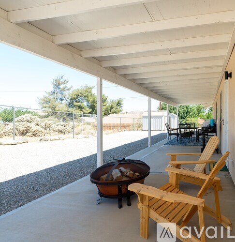 A patio with a white ceiling and a fire pit.