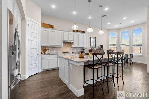 A kitchen with white cabinets and a marble countertop.