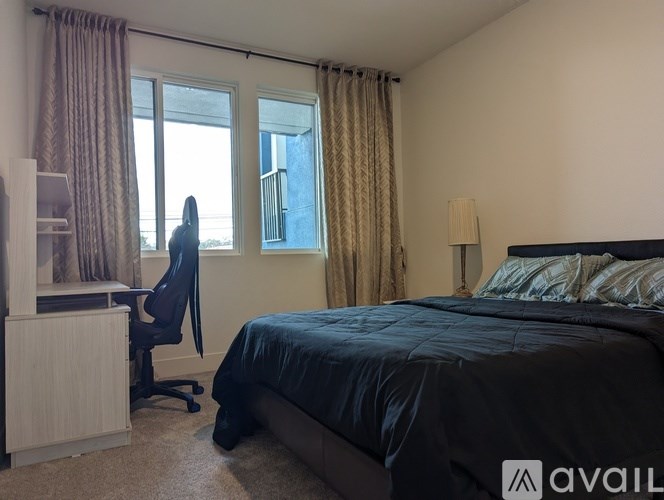 A bedroom with a bed, desk, and chair.