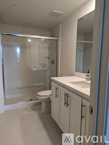 A bathroom with a toilet, sink, and shower.