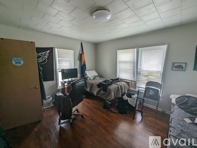 A room with a bed, a chair, and a desk.