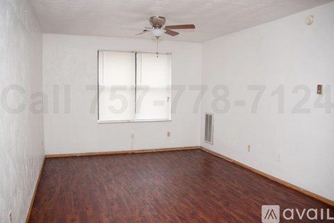 A room with a wooden floor and a ceiling fan.