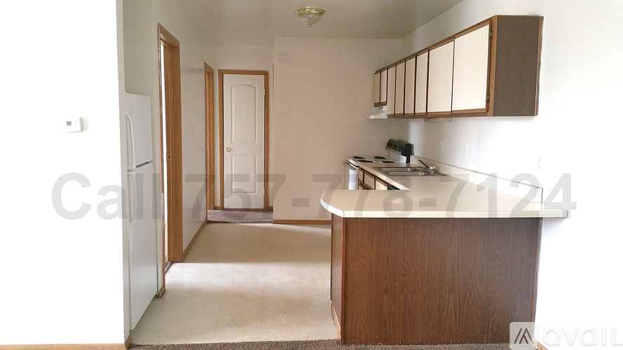 A kitchen with a sink, refrigerator, and cabinets.