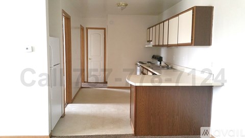 A kitchen with a sink, refrigerator, and cabinets.