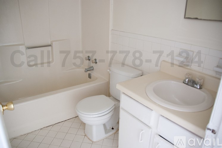 A white toilet sits next to a bathtub in a bathroom.