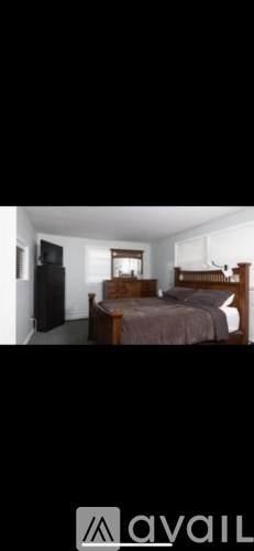 A bedroom with a bed, dresser, and mirror.