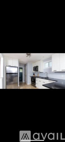 A kitchen with white cabinets and a black countertop.