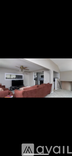 A living room with a red couch and a television.