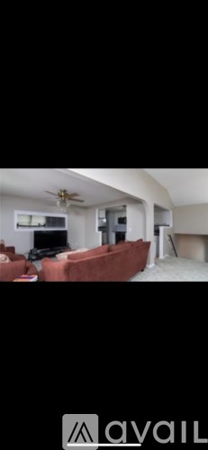 A living room with a red couch and a television.