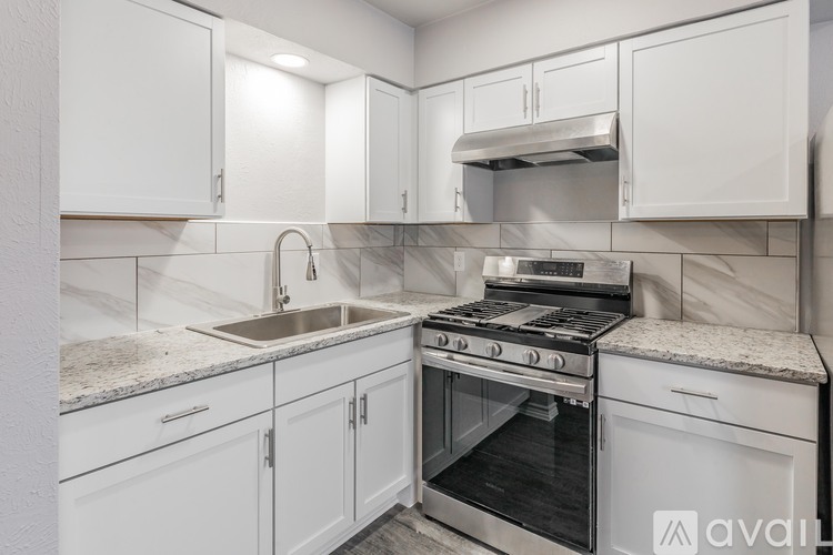 A kitchen with white cabinets and a stainless steel oven.