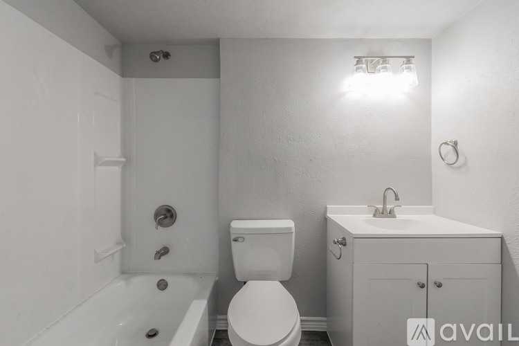 A white bathroom with a toilet, sink, and bathtub.