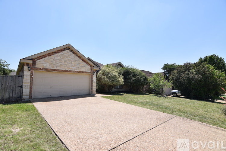 A house with a garage and driveway in front of it.