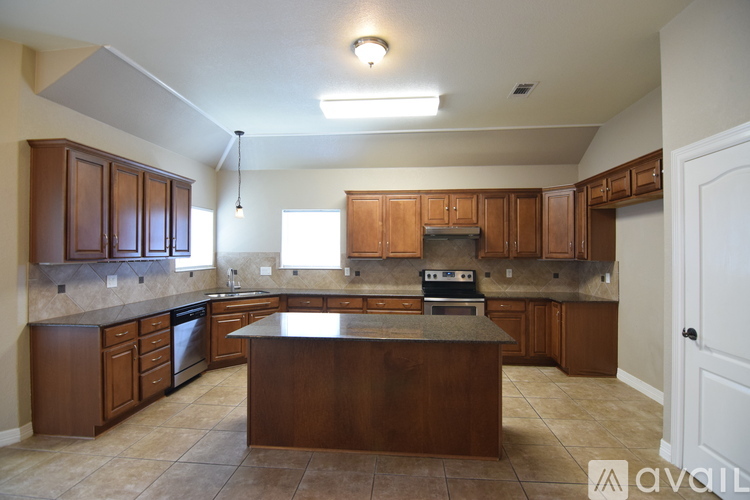 A kitchen with brown cabinets and a central island.