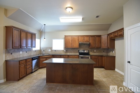 A kitchen with brown cabinets and a central island.