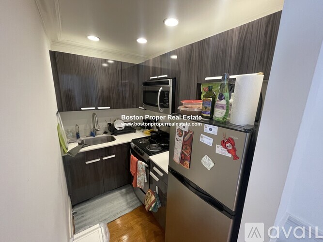 A kitchen with a refrigerator, sink, and stove.