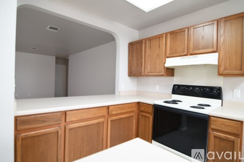 A kitchen with wooden cabinets and a black stove top.