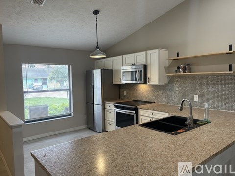 A kitchen with granite countertops and white cabinets.
