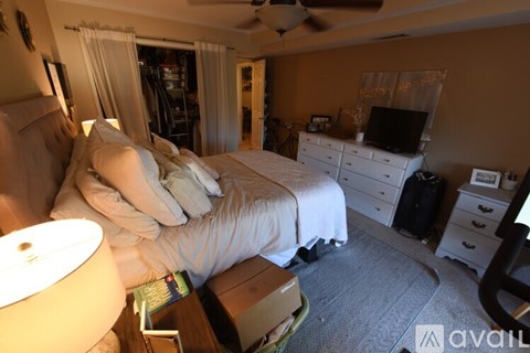 A bedroom with a bed, dresser, and ceiling fan.