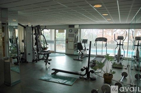 A gym with a variety of equipment including treadmills, weights, and exercise machines.