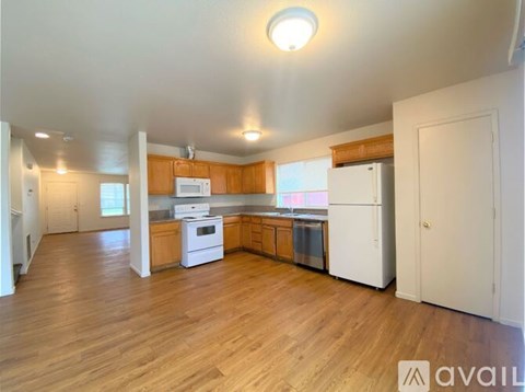 A kitchen with wooden floors and white appliances.
