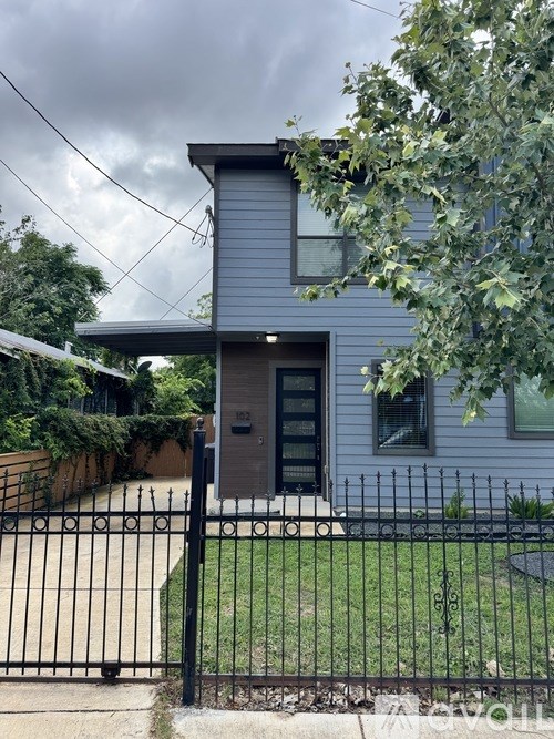 A house with a grey exterior and a black gate.