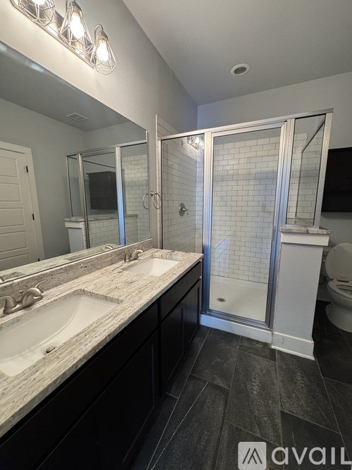 A bathroom with a marble countertop and a walk-in shower.