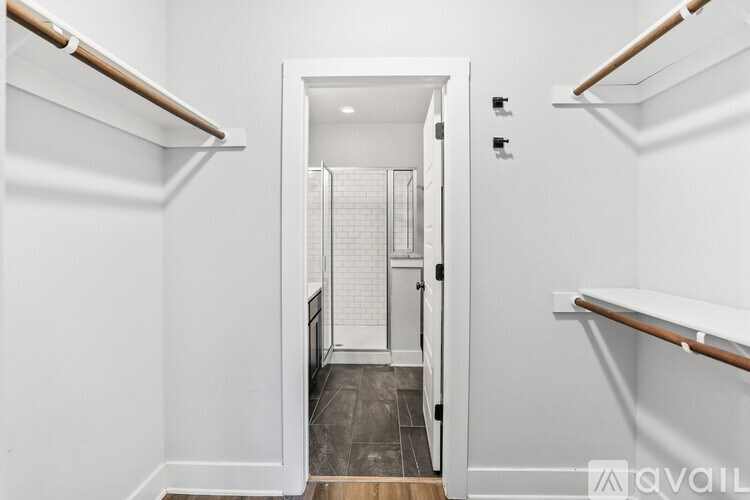 A room with a ceiling fan and light fixture, and a wooden floor.