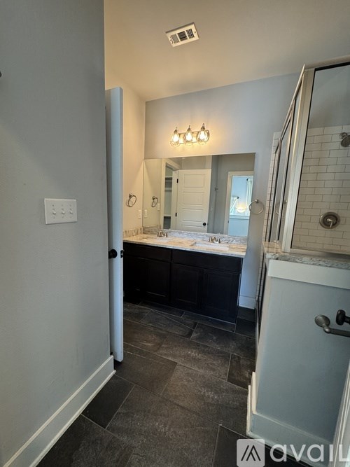A bathroom with a mirror, a sink, and a light switch.