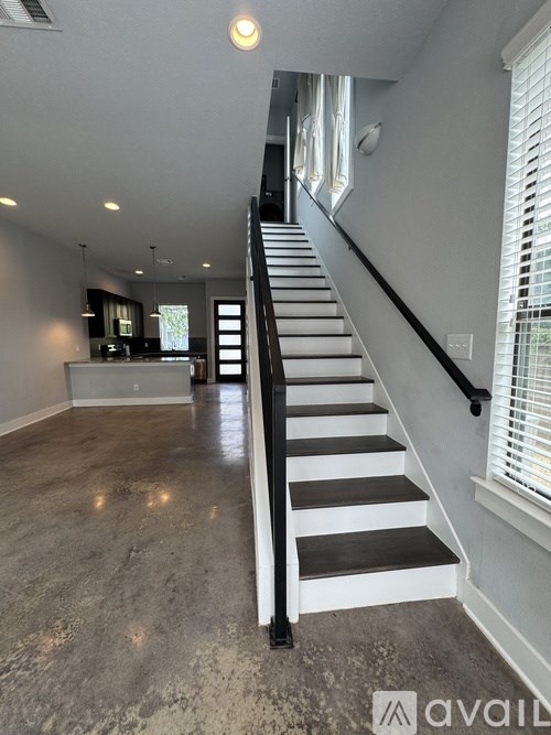 A staircase with black railings and white steps leads up to a window.