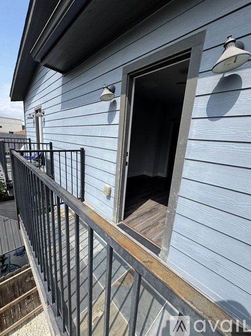 A balcony with a railing and a doorway leading to the interior of a house.