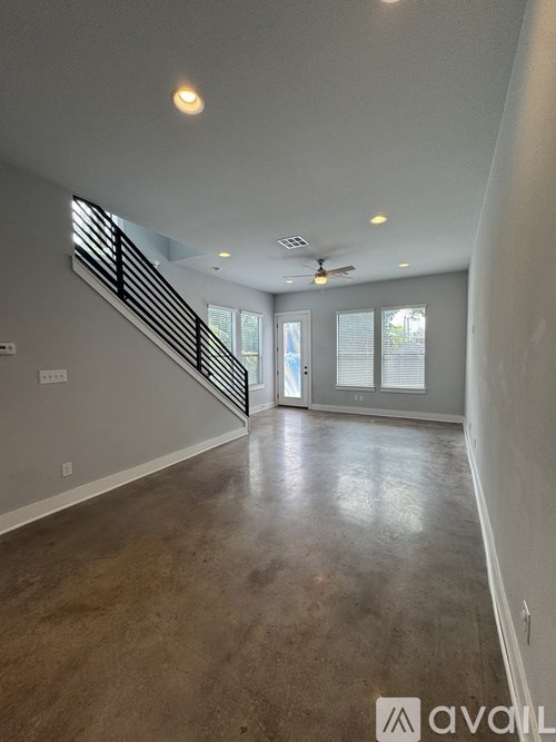 A spacious room with a staircase leading to the second floor.