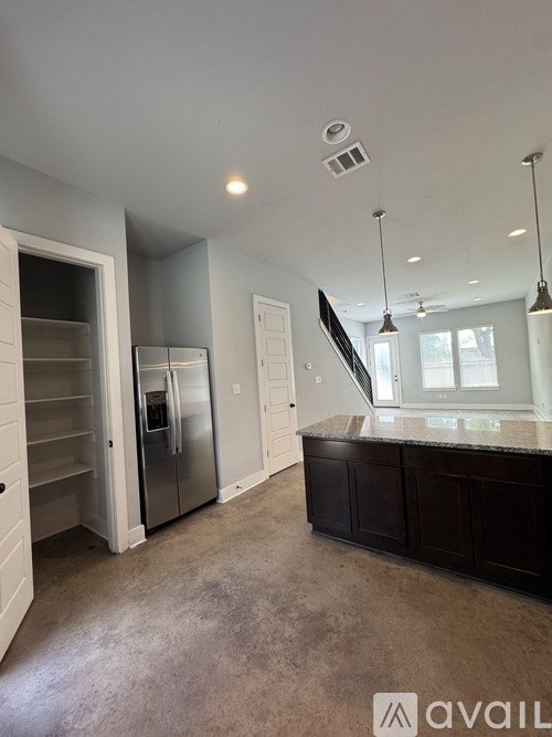 A kitchen with a refrigerator, cabinets, and a countertop.