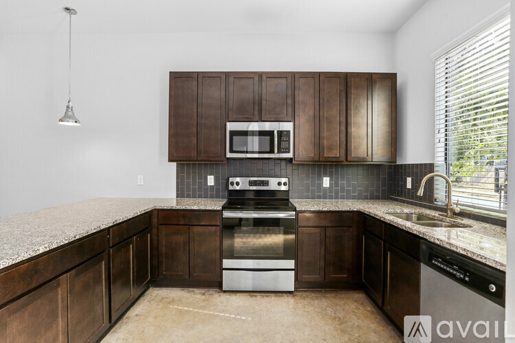 A kitchen with dark brown cabinets and a stainless steel stove.