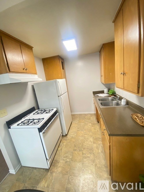 A kitchen with a white stove top oven and a white refrigerator.