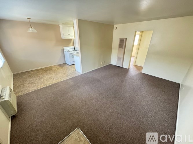 A room with a carpeted floor and a washing machine in it.